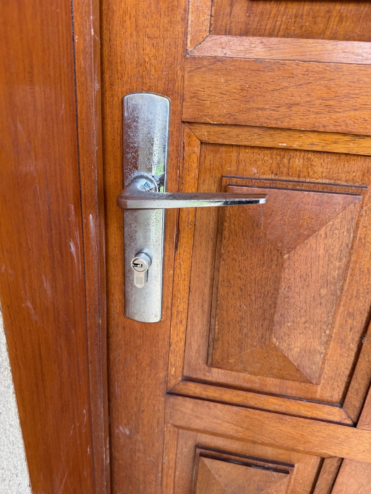 Cylindre et poignée métallique sur une porte en bois