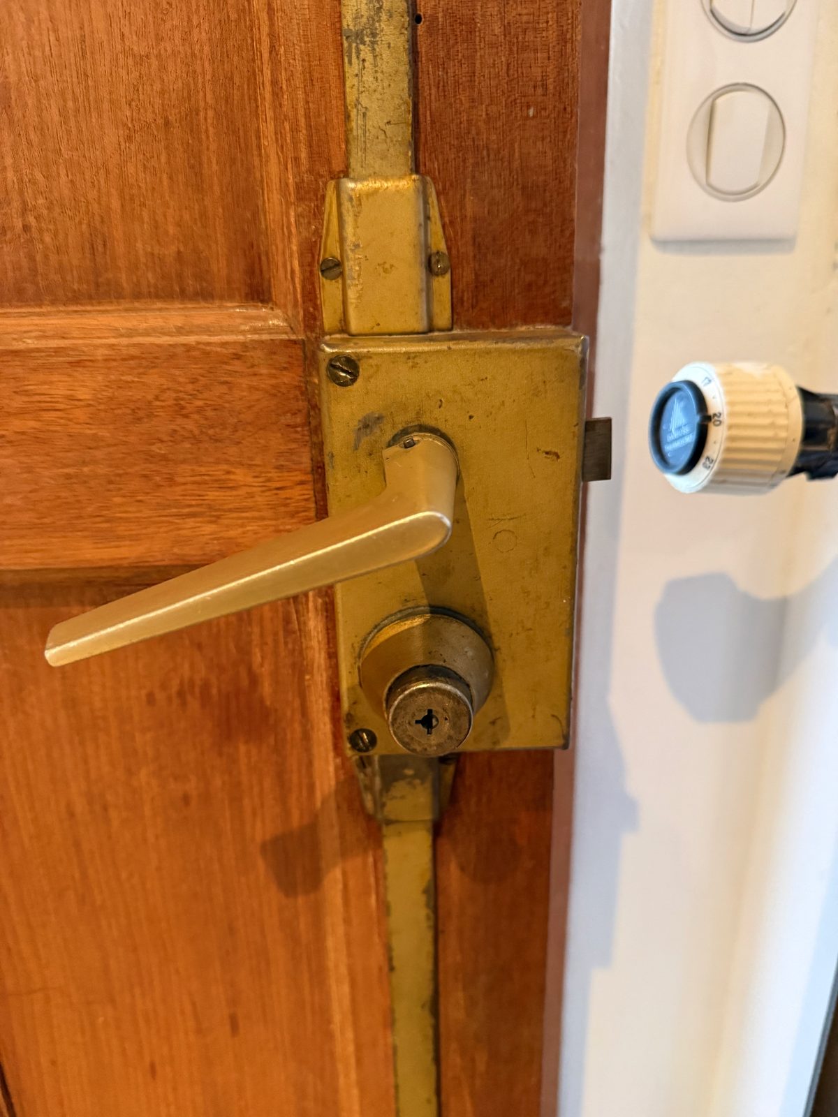 Poignée et mécanisme de serrure multipoints sur une porte en bois