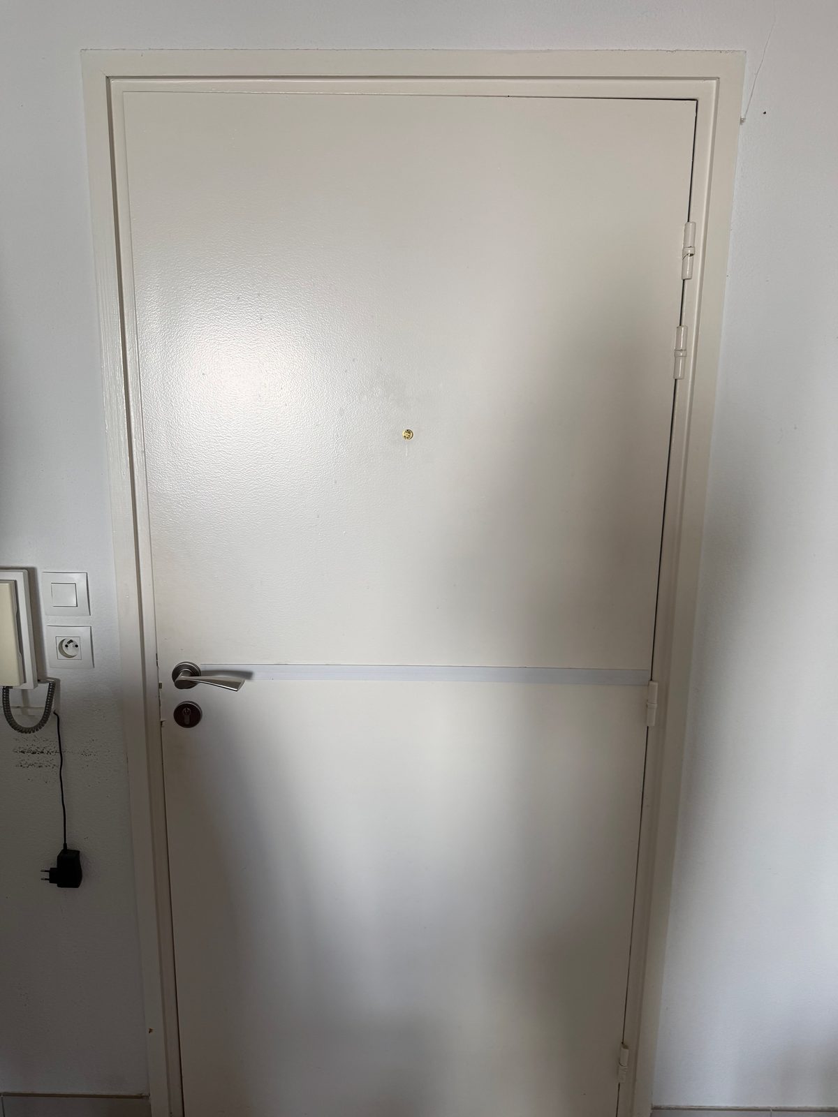 Porte d’appartement métallique blanche avec serrure