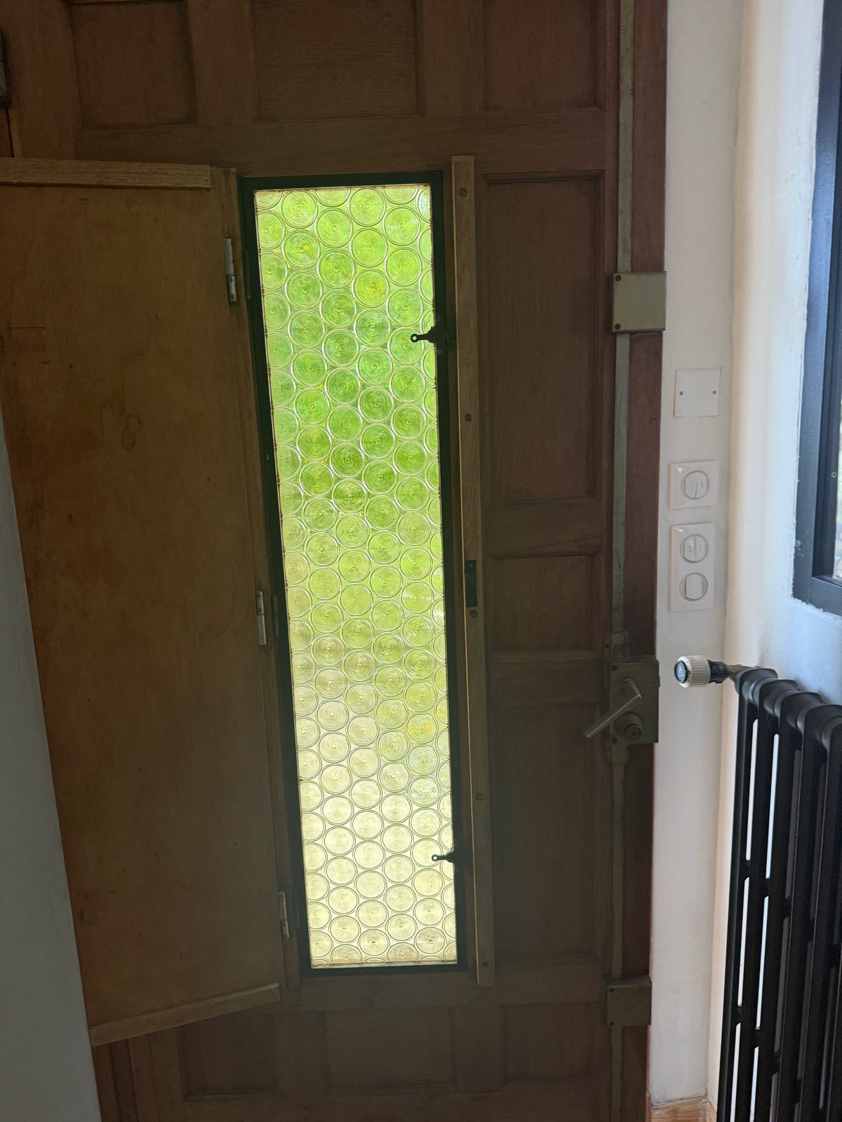 Vitrage décoratif intégré à une porte d’entrée en bois