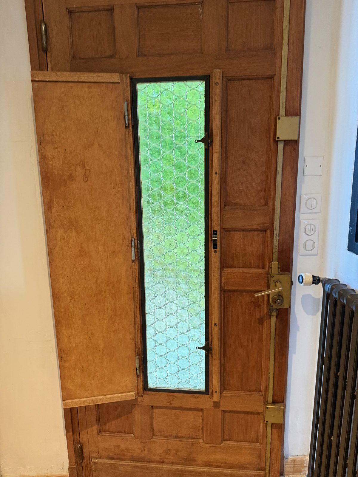 Porte d’entrée en bois vitrée équipée d’une serrure
